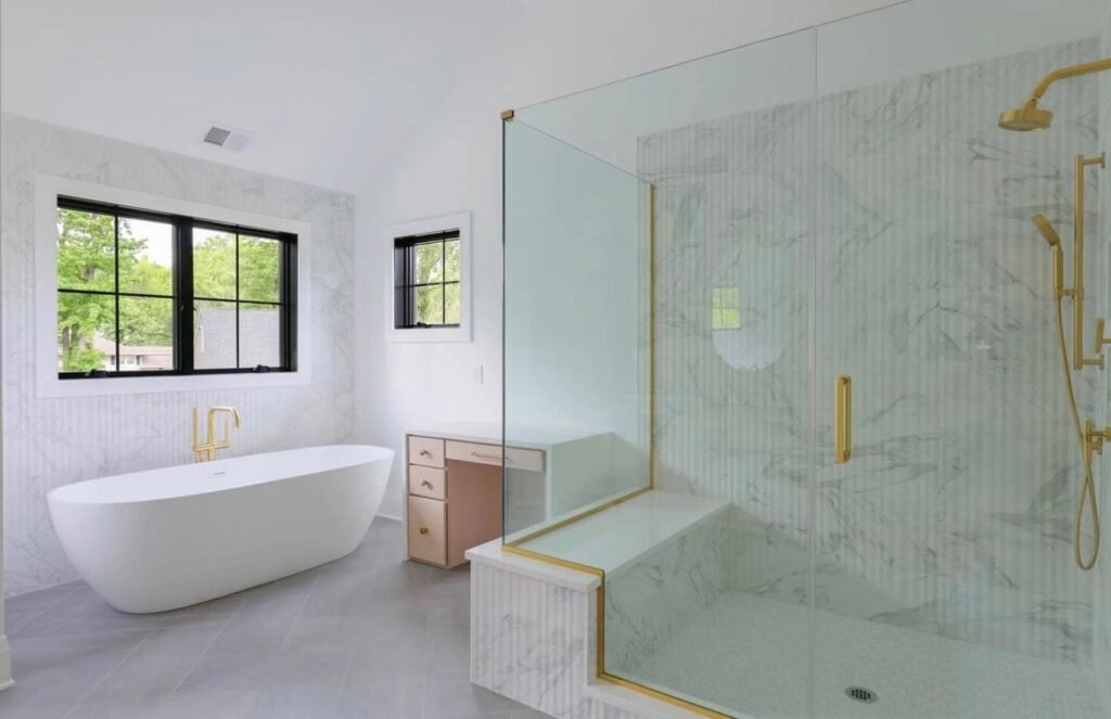 Primary bath with marble-look wall tile, glass shower and freestanding tub
